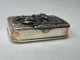 an antique silver box with a horse design on the lid