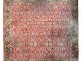 un tapis persan ancien à fond rose et bordure dorée