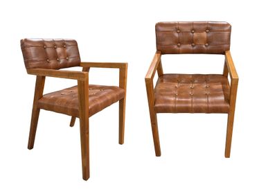 deux chaises en cuir marron assises l'une à côté de l'autre sur une surface blanche