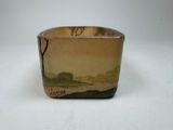 a small vase with a painting on it on a table