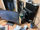a desk with a computer monitor, keyboard, mouse, and other items on it