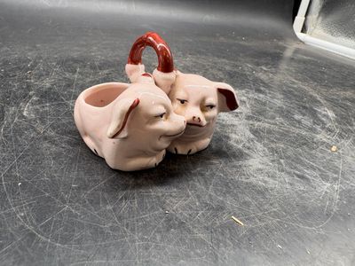 two ceramic pigs that are sitting on a table