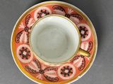 a close up of a cup and saucer on a table