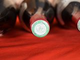 several bottles of wine are lined up on a red cloth