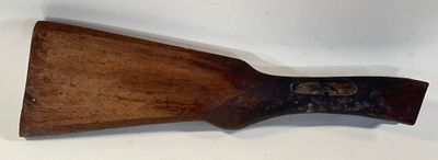 une vieille pagaie en bois avec un manche en bois posée sur une surface blanche
