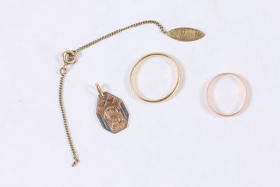 deux bagues, un collier et une bague posés sur une surface blanche