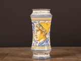 un vase bleu et jaune sur lequel est représentée une femme