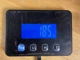 a digital clock on a table with a charger