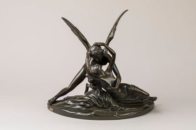an image of a bronze statue of a woman sitting on a leaf
