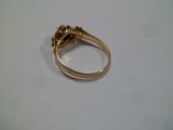 une bague en or ornée d'un diamant sur une surface blanche