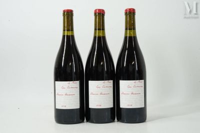 trois bouteilles de vin rouge posées l'une à côté de l'autre sur une surface blanche