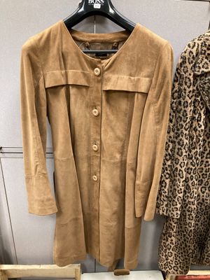 deux manteaux et un manteau à imprimé léopard sont suspendus à un portemanteau