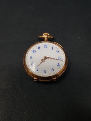 une montre de poche en or avec un cadran bleu sur fond noir