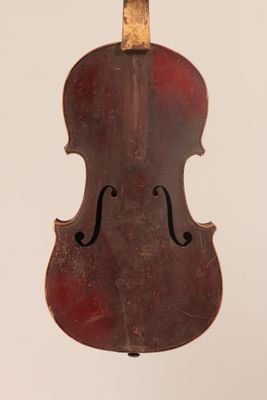 un vieux violon suspendu à une ficelle sur un mur blanc