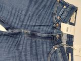 the jeans are blue and have buttons on them and a tag on the back of the pants