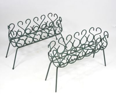 pair of wrought iron garden benches with curved arms and legs