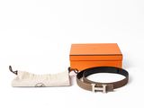 une ceinture en cuir marron avec une boucle en argent et une petite pochette