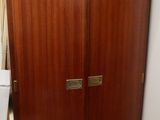 un grand meuble en bois dans le coin d'une pièce