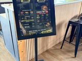 un panneau présentant le menu, posé sur un support, dans un restaurant