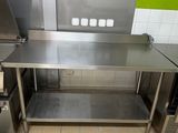 une grande cuisine en inox avec un mur végétal