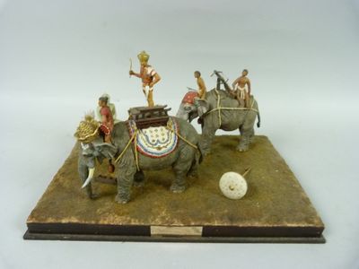 une figurine représentant un groupe de personnes chevauchant des éléphants