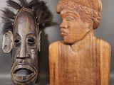 two carved wooden masks are sitting next to each other on a table