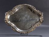 an antique silver plate with a decorative design on a stand
