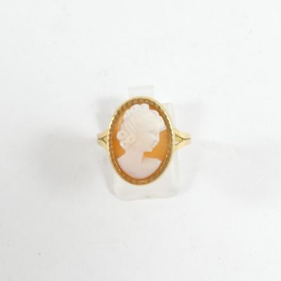 gros plan d'une bague en or avec un camée représentant une femme