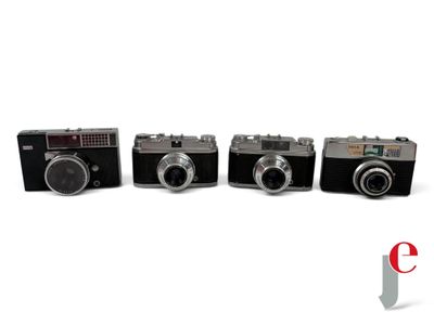 four cameras are lined up in a row on a white surface