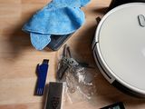someone is cleaning a table with a robotic vacuum cleaner and other items