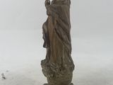 statue of a woman holding a child on a pedestal in the snow