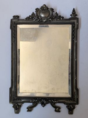 an antique mirror hanging on a wall in a room