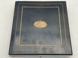 an old black box with gold trim and a gold medallion on it