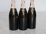 three bottles of wine are lined up on a marble surface