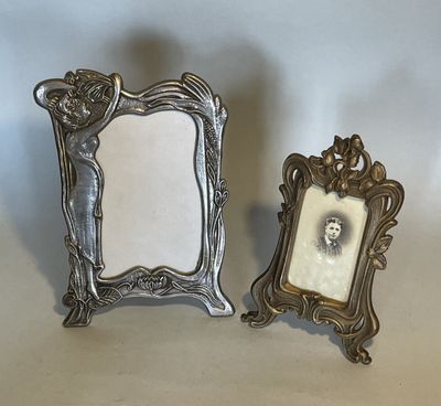 two silver picture frames sitting next to each other on a table