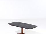 une image représentant une table noire avec un piètement en bois sur fond blanc