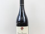 une bouteille de vin rouge posée sur une table blanche