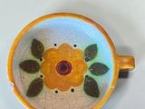 a small bowl with a flower painted on it