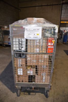 un chariot métallique sur lequel sont posées des caisses, dans un entrepôt