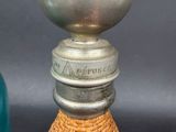 a person holding a bottle that has a metal cap on it