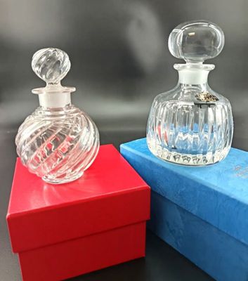 two bottles of perfume sitting on top of a blue box
