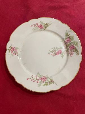 un gros plan d'une assiette décorée de fleurs, posée sur une nappe rouge