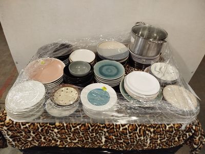 de nombreuses assiettes et bols posés sur une table recouverte d'un film plastique