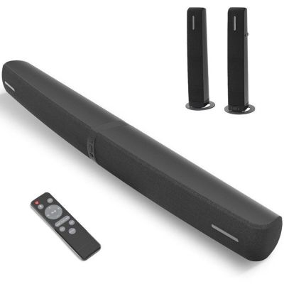 two black speakers and a remote on a white surface