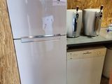 a white refrigerator in a kitchen with a lot of counter space
