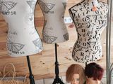 trois mannequins posés sur un socle devant un mur