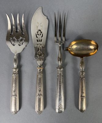 quatre fourchettes et une cuillère sur une table, avec une cuillère au milieu