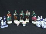 seven figurines of people dressed in different costumes