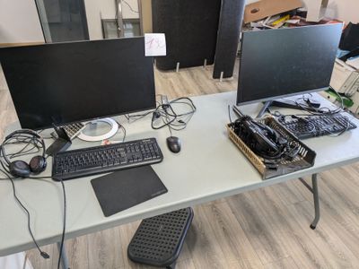 a desk with a keyboard, monitor, mouse and other electronics on it