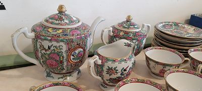 many plates and cups and a teapot on the table